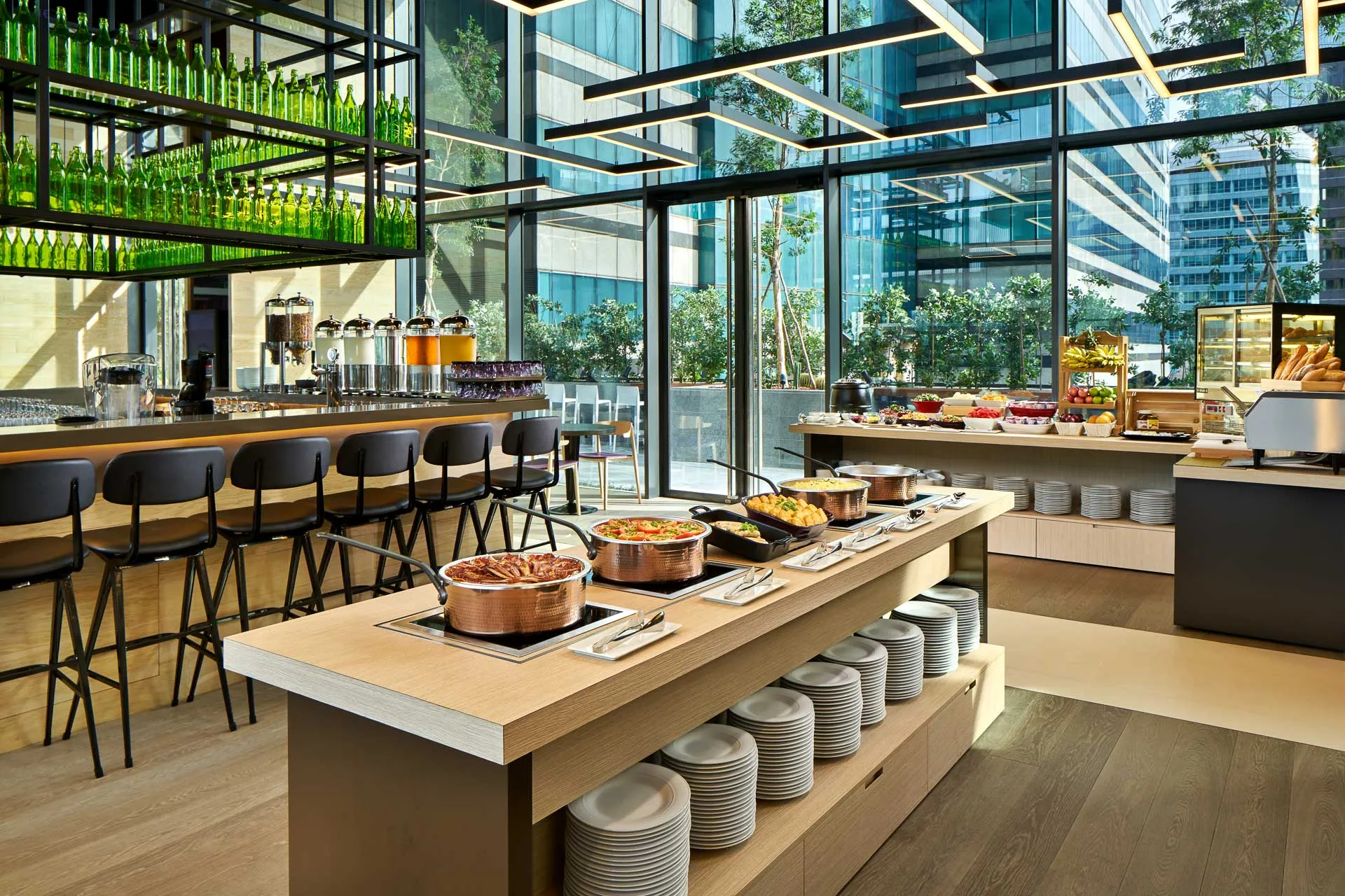 Restaurant with buffet island, industrial shelving and terrace views — YOTEL Singapore interior photography