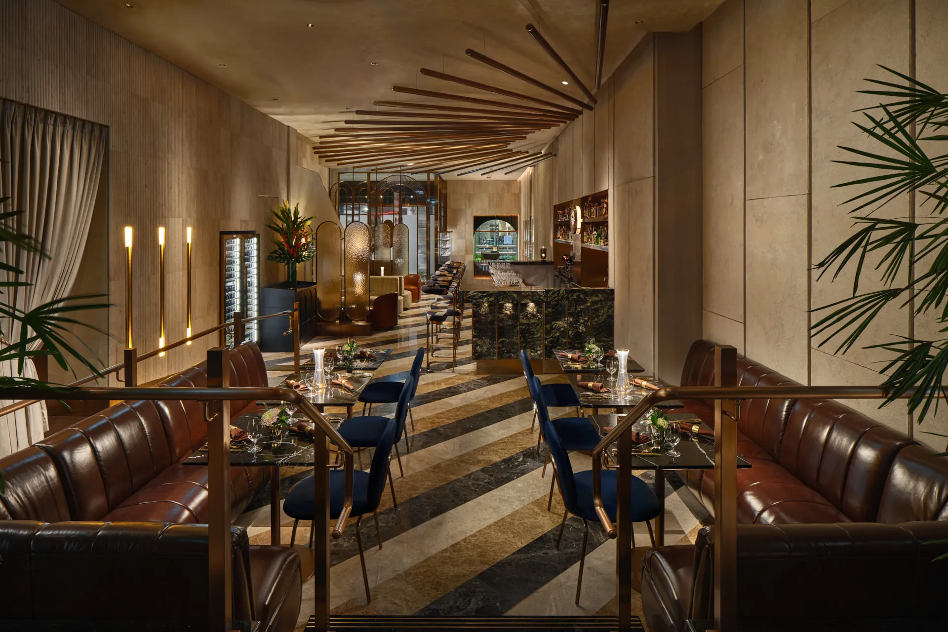 Dining corridor with brass rail dividers, striped marble floor and copper ceiling — 33 Club Singapore interior photography