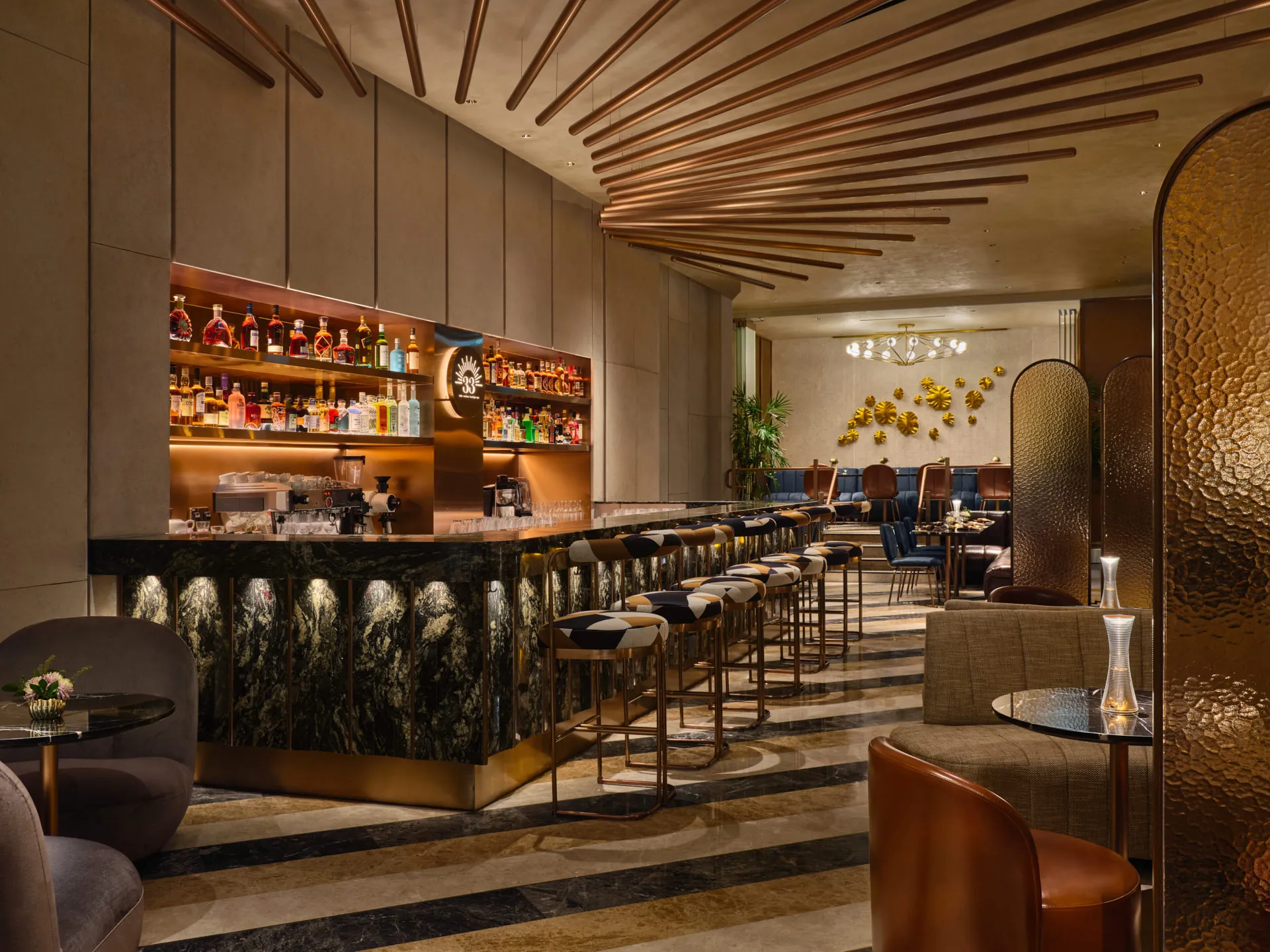 Bar with green marble counter, copper ceiling rods and brass-trimmed stools — 33 Club Singapore commercial interior photography