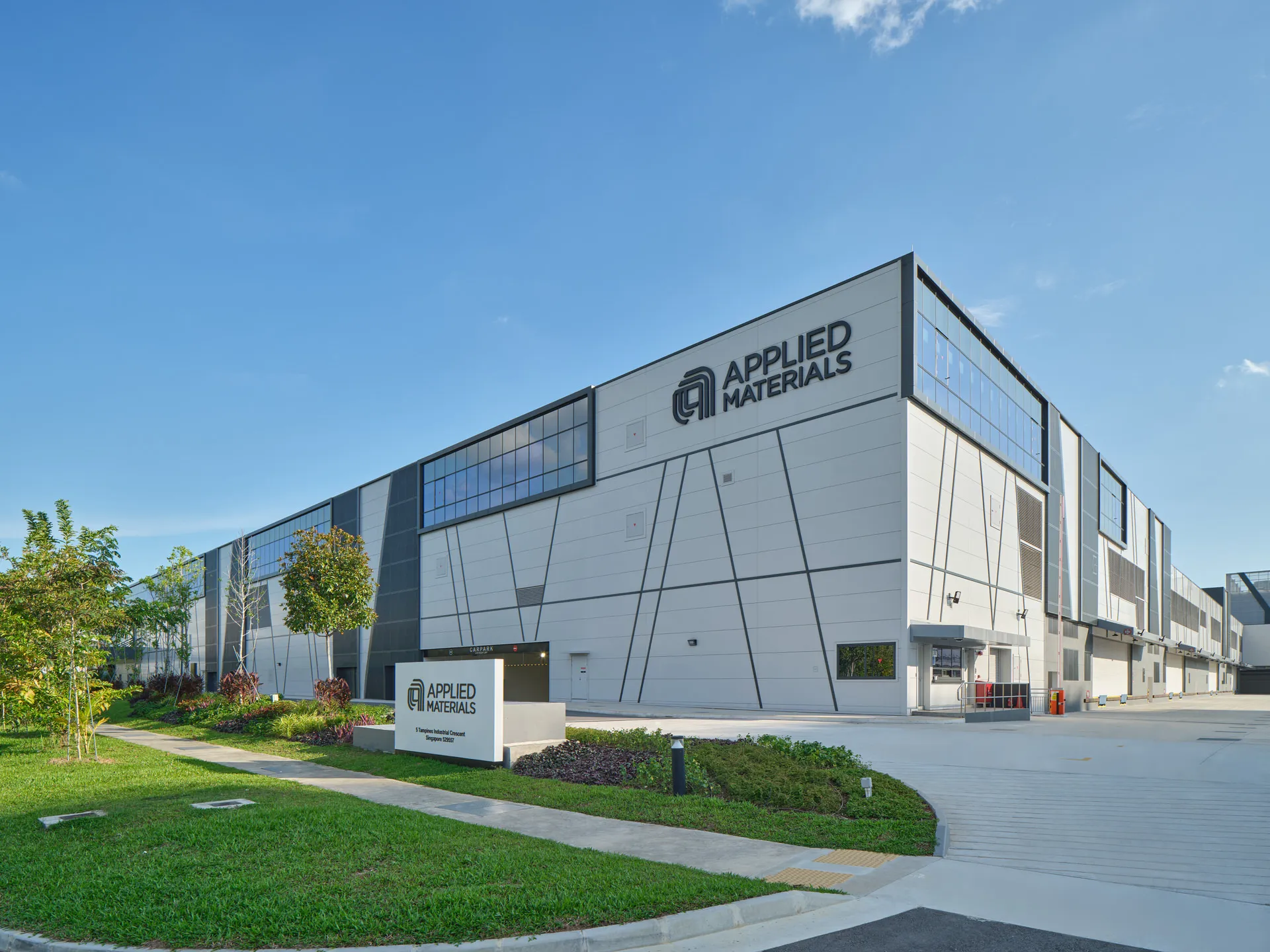 Approach view with branded signage, angular facade and tropical landscaping — Trimo Singapore architectural photography