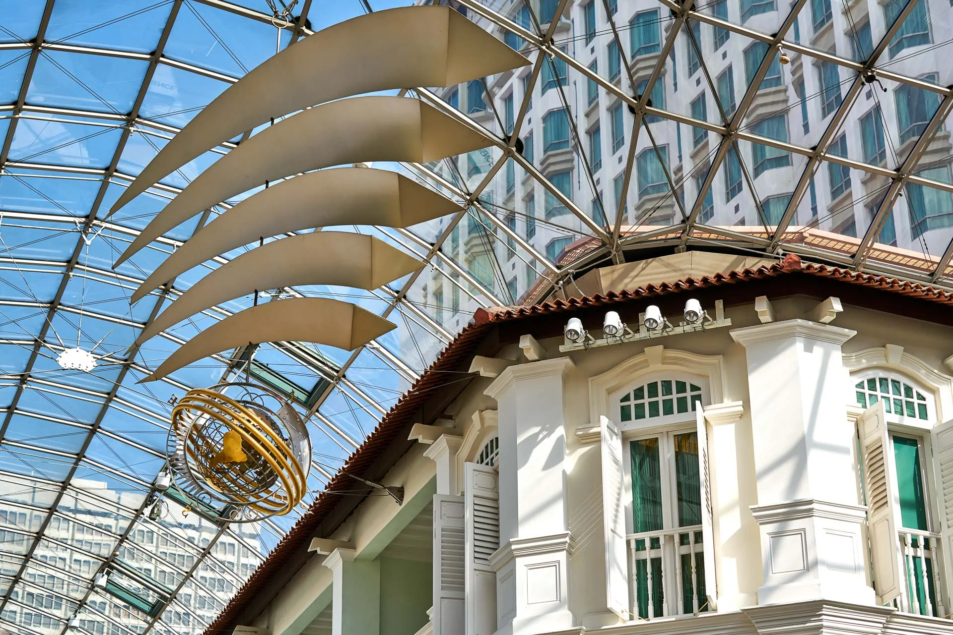 Armillary sphere sculpture and fabric baffles in glass atrium — Bugis Junction Singapore architectural photography
