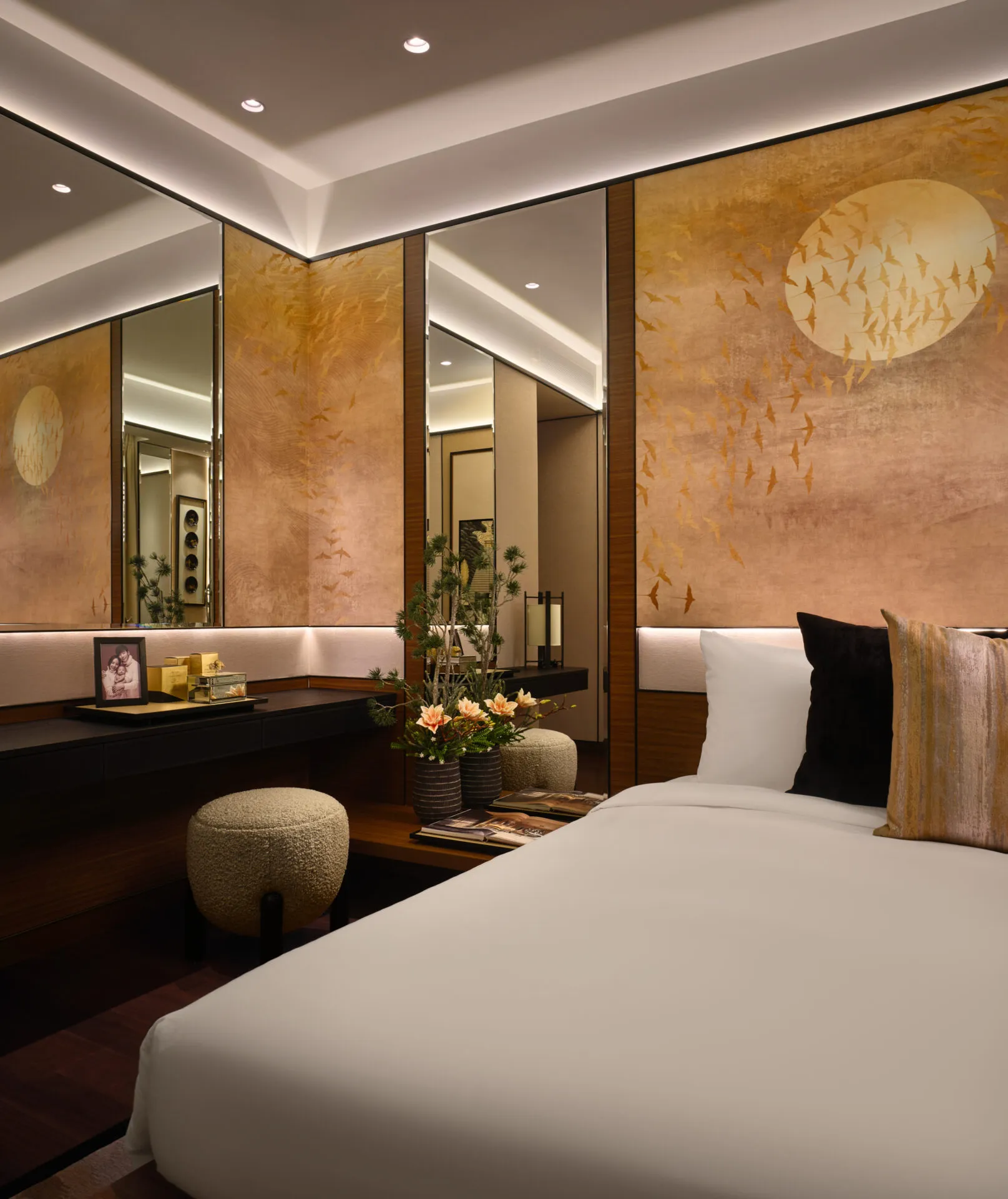 Bedroom with gold bird panels, ikebana and recessed glow — Boulevard 88 Singapore residential interior photography