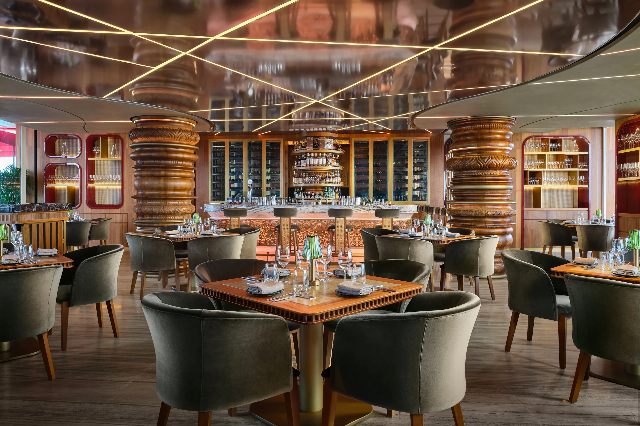 Professional interior photography of the CÉ LA VI Singapore restaurant, capturing the warm ambient lighting on the elegant circular booths and detailed ceiling.