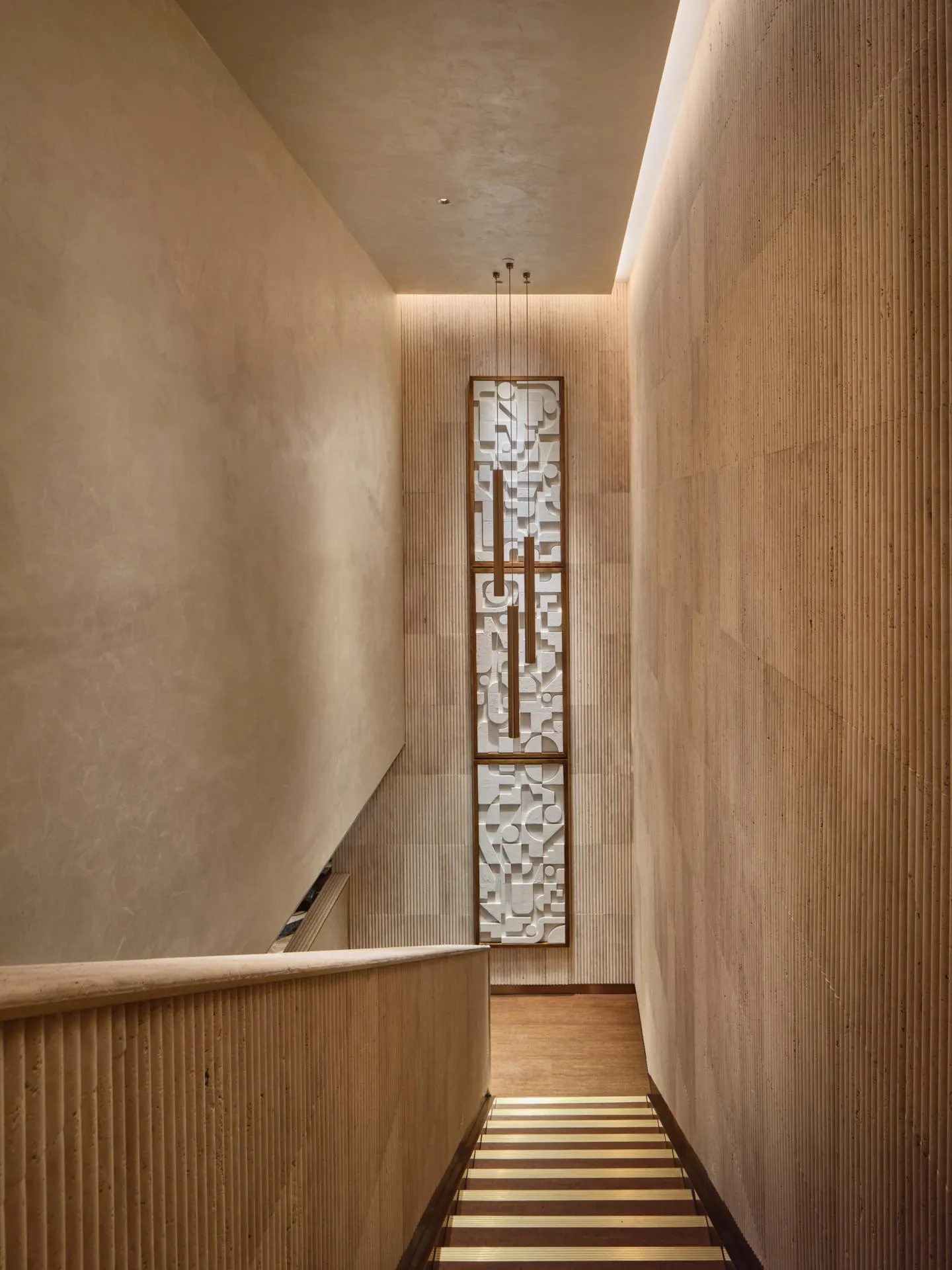 Stairwell with fluted sandstone panels and geometric relief sculpture — 33 Club Singapore architectural photography