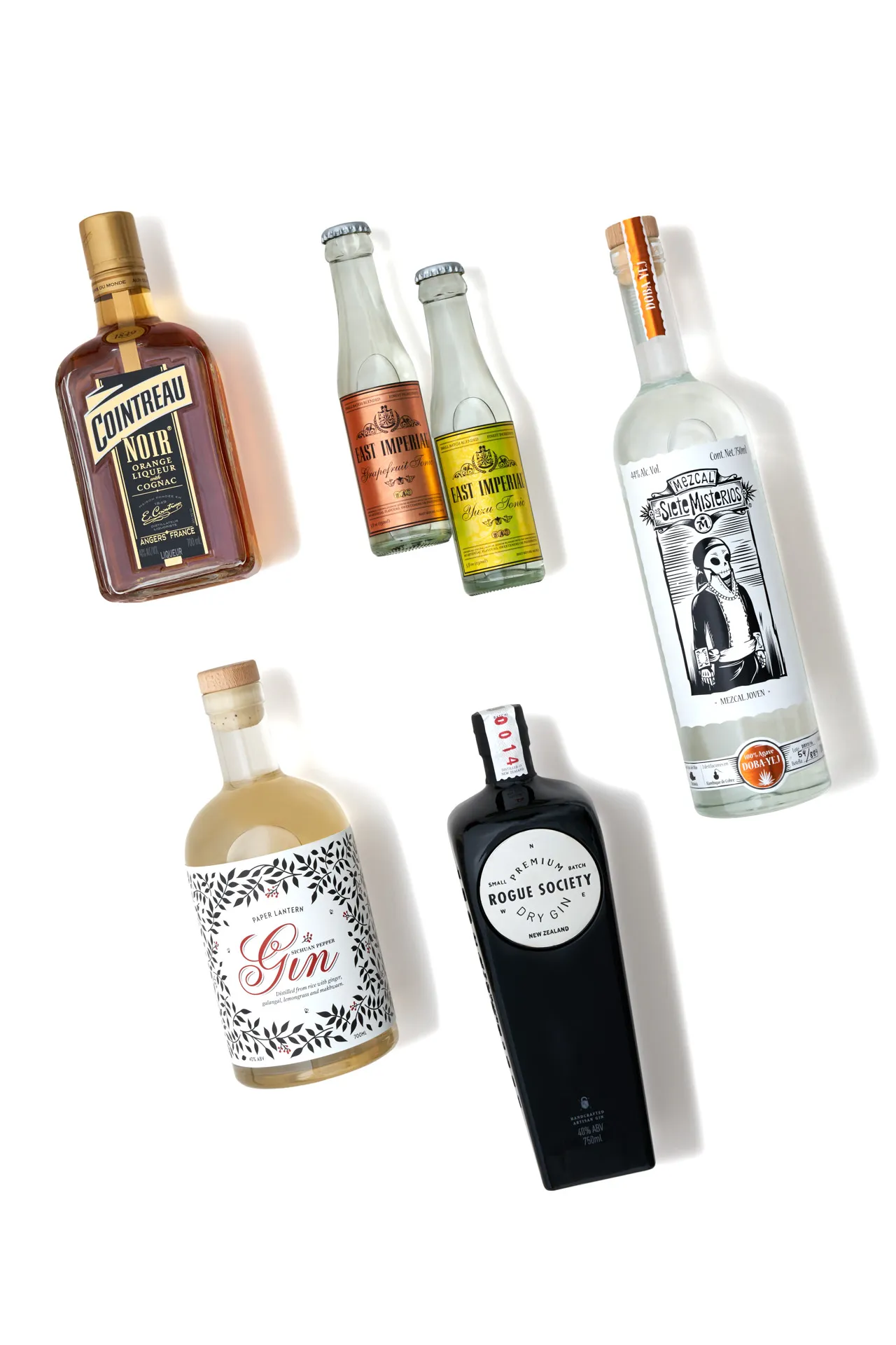 Five spirit bottles on white seamless background with soft studio lighting — Drink Magazine beverage photography