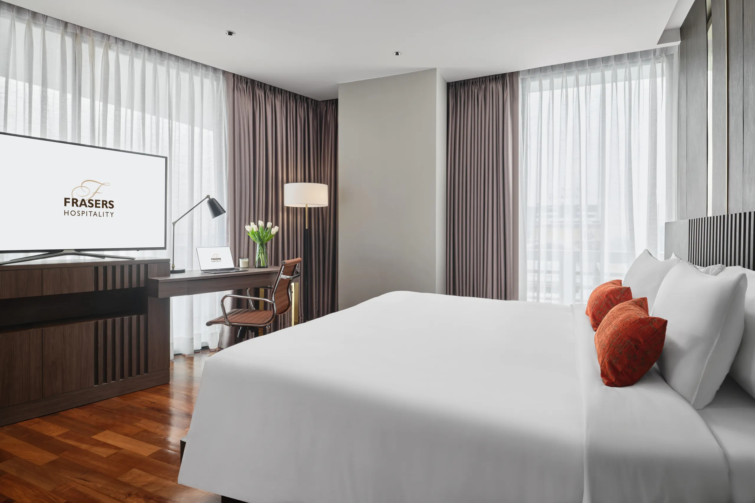 Suite bedroom with TV, work desk and drum-shade floor lamp — Fraser Suites Sukhumvit interior photography