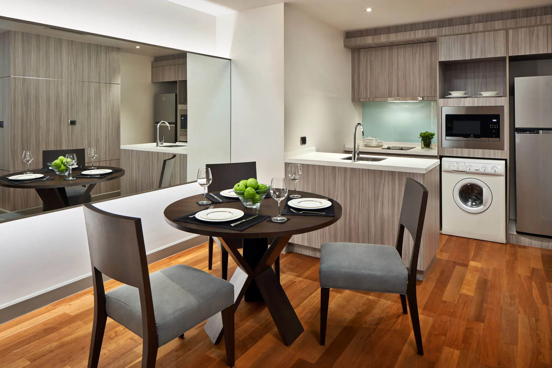 Compact kitchen-dining with mint backsplash and wall mirror — Fraser Suites Sukhumvit Bangkok hotel photography