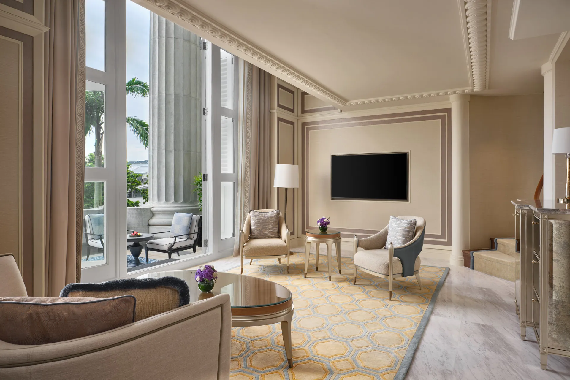 Living area with honeycomb rug, stone columns and French door daylight — Fullerton Hotel Singapore loft suite photography