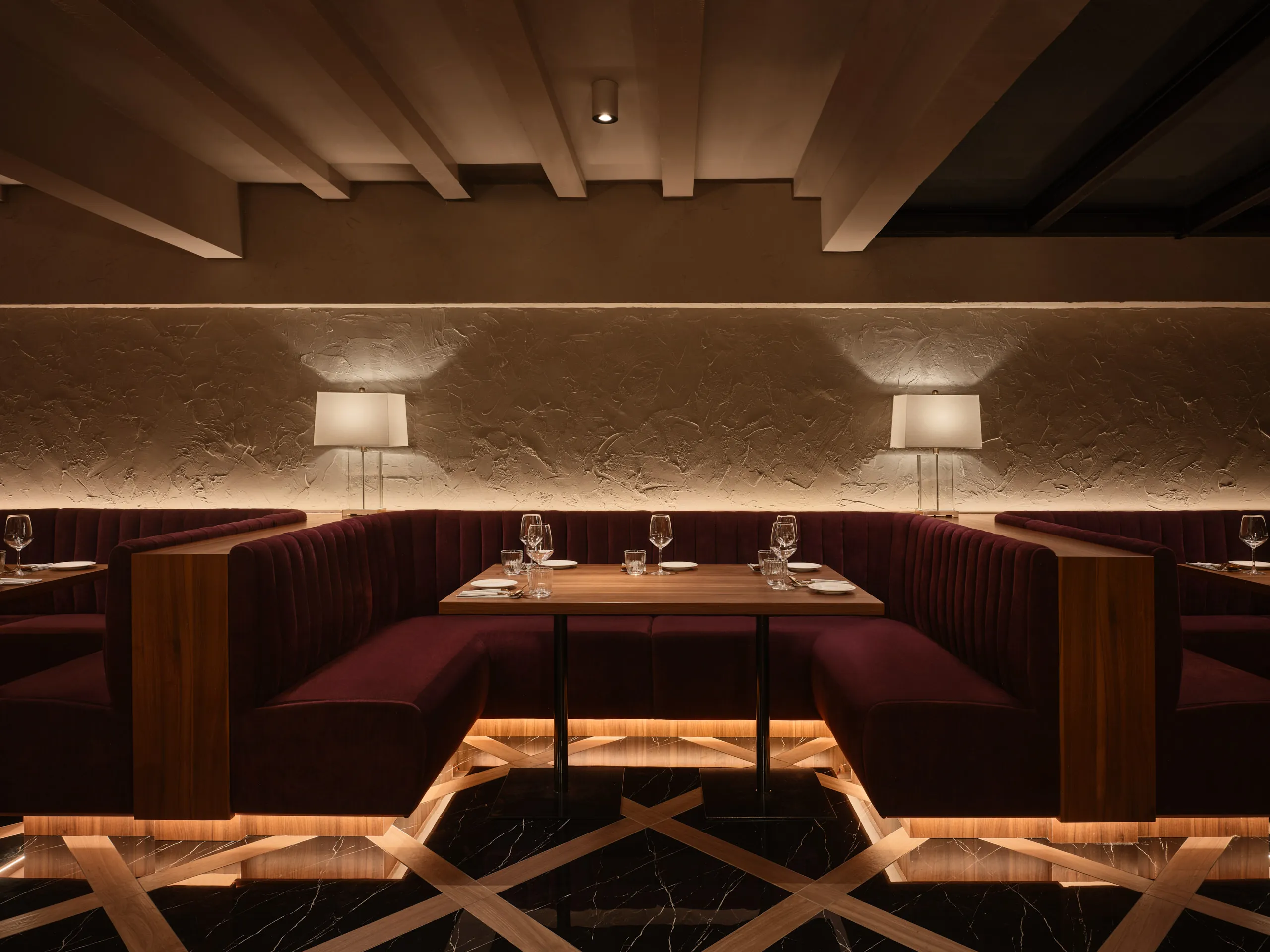 F&B interior design at Gotti Singapore, showcasing intimate booth seating with warm ambient lighting and textured wall details.
