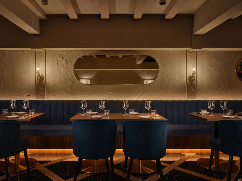 F&B interior design at Gotti Singapore, capturing a stylish dining setup with deep blue chairs and contemporary decor.