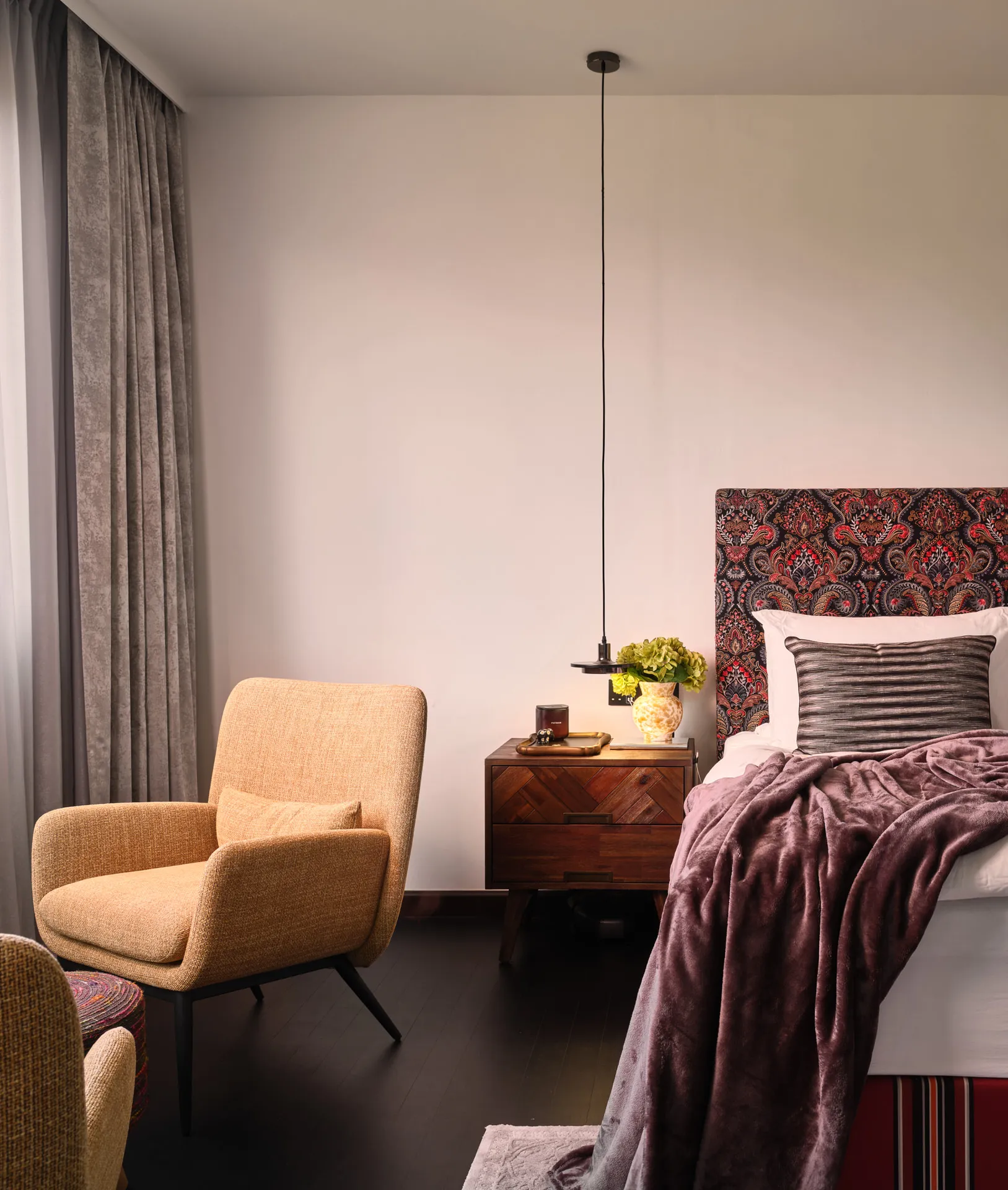 Bedroom with paisley headboard, aubergine throw and mustard armchair — Holland Green Singapore residential photography