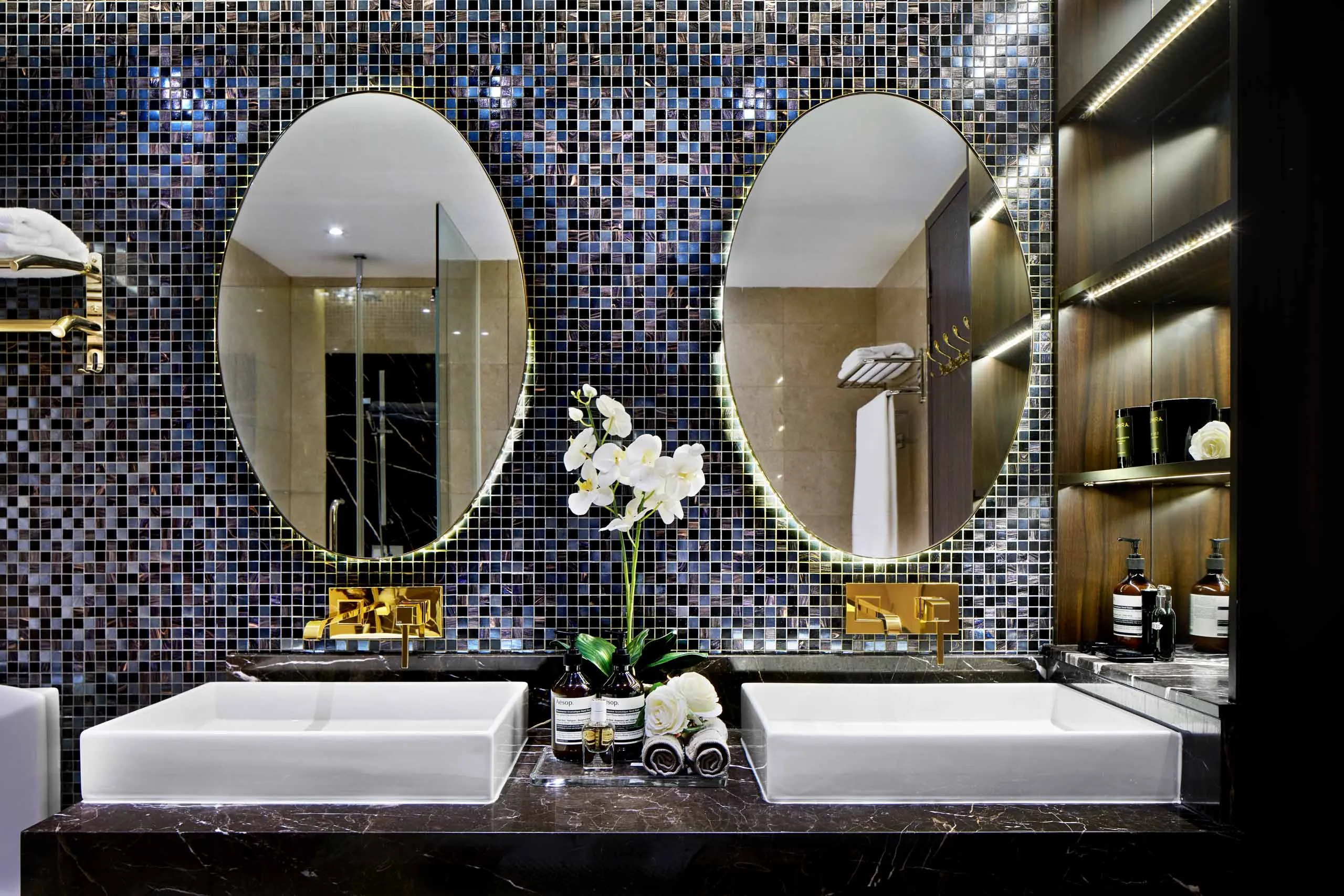 Luxury master bathroom with twin sinks, mirrors, and mosaic wall – residential interior photography at Marina Bay Suites