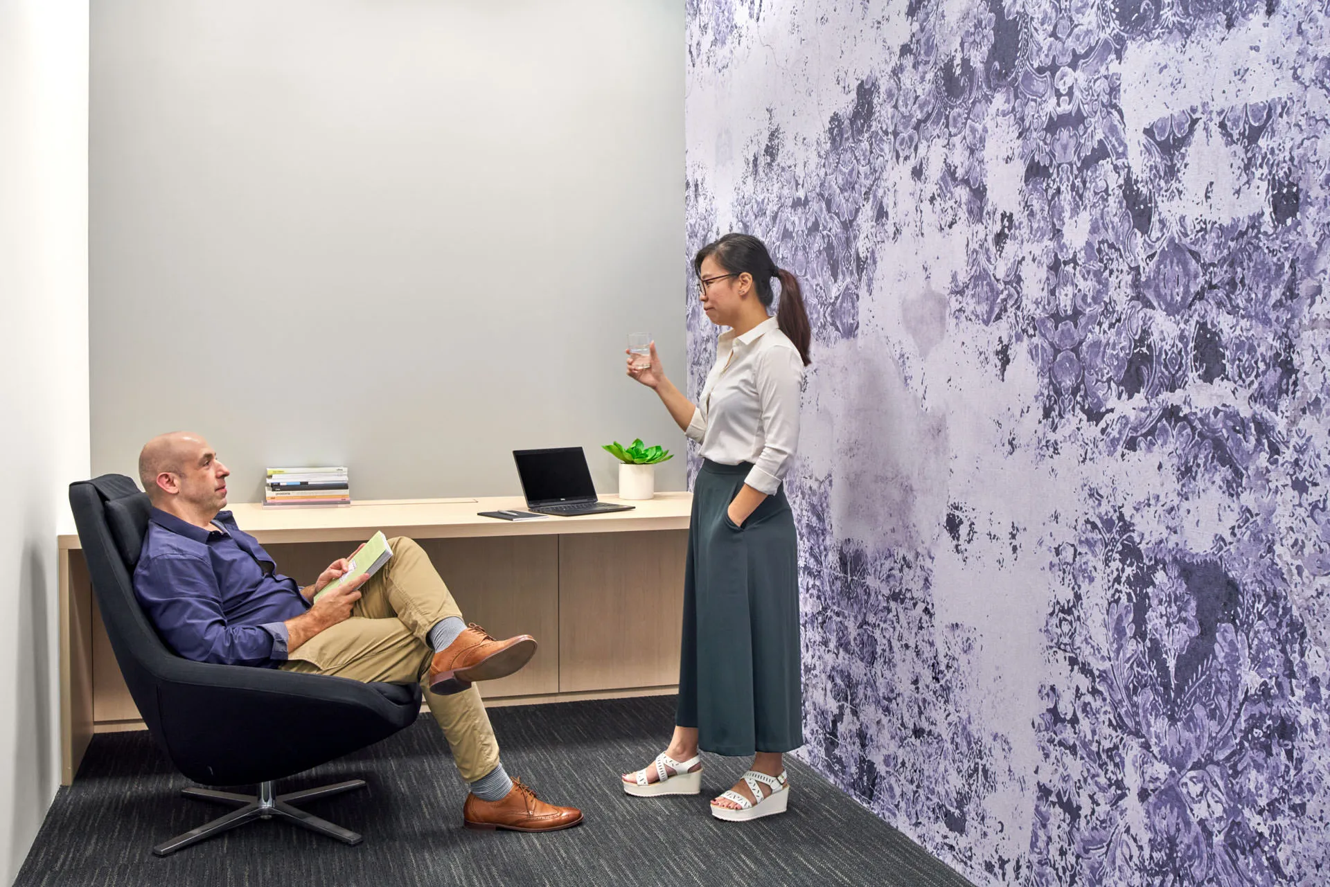 Breakout nook with purple floral feature wall and floating timber ledge — King Wood Mallesons Singapore workplace photography