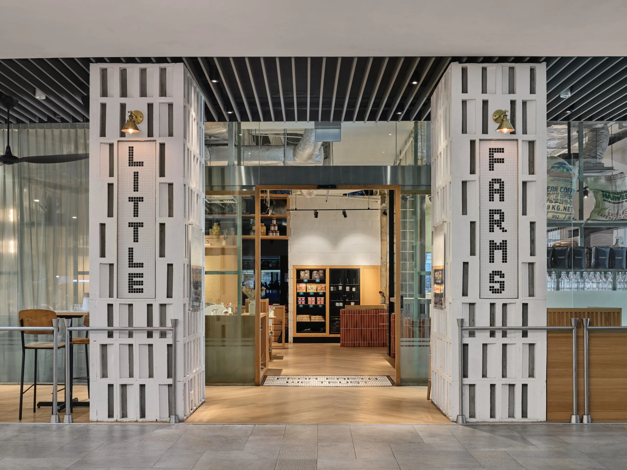 Main entrance with large glass doors and branded signage – restaurant interior design photography at Little Farms Valley Point