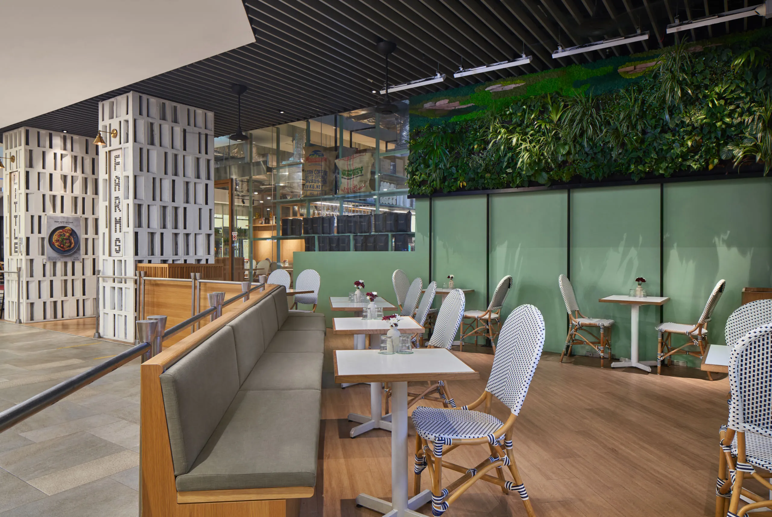 Outdoor dining area with greenery and comfortable seating – restaurant interior design photography at Little Farms Valley Point