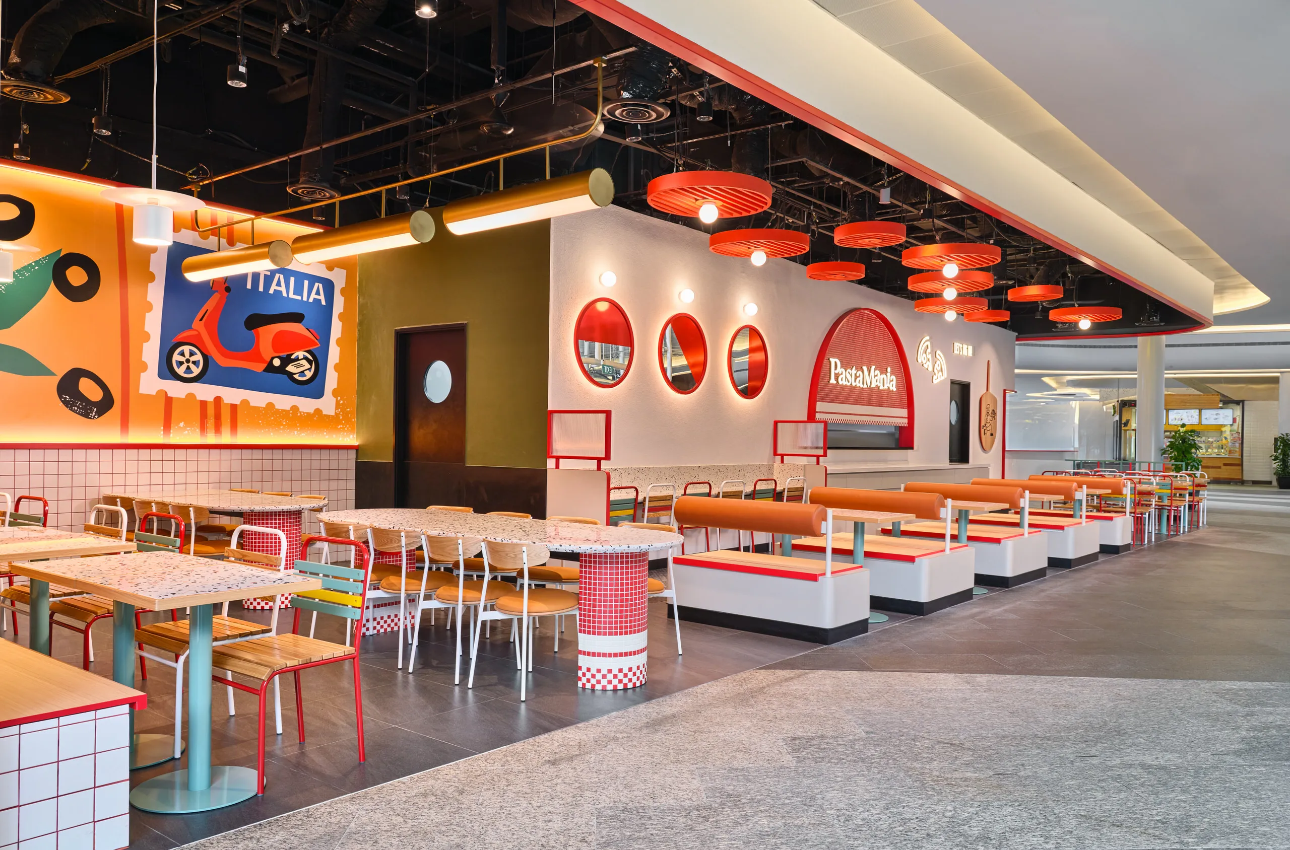 Full dining hall with red disc pendants, terrazzo tables and Italian colour story — PastaMania interior design photography