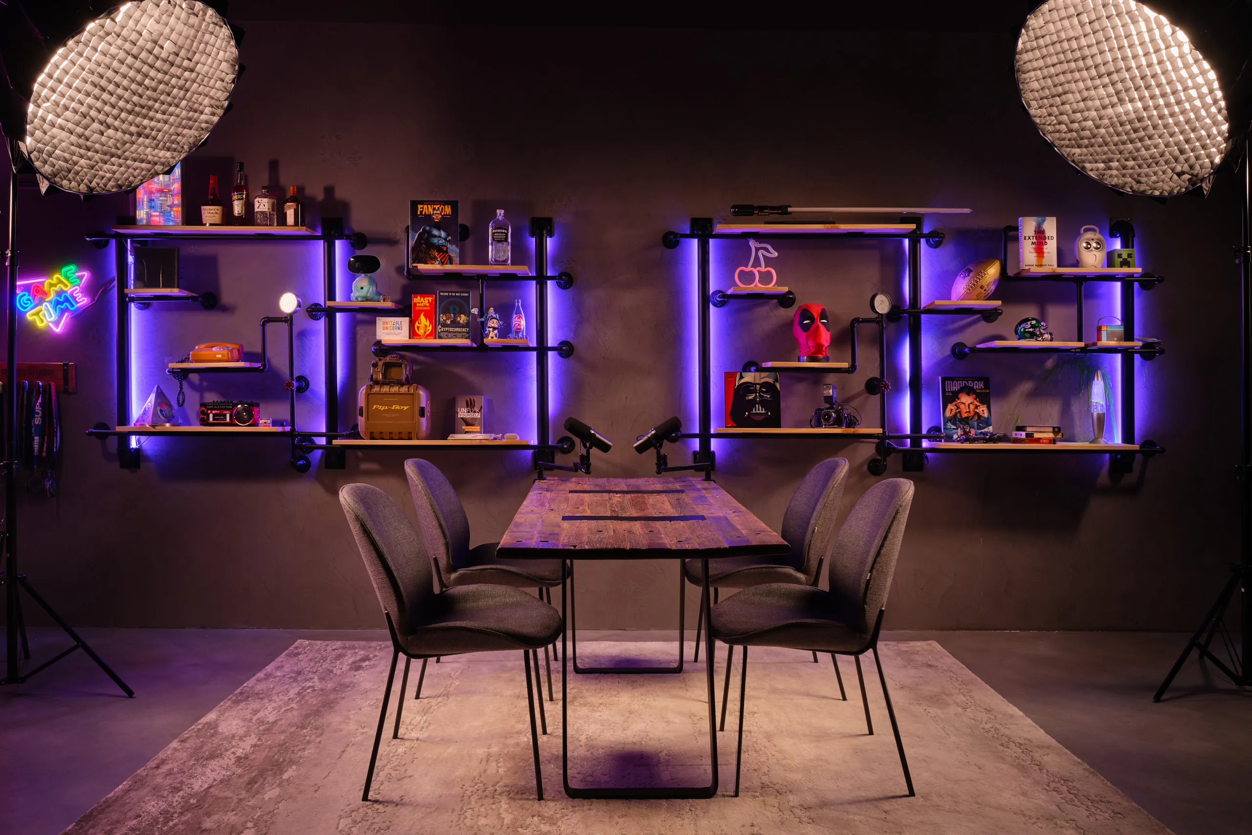 Industrial gaming podcast studio with purple LED pipe shelving and pop culture memorabilia — Poddster Singapore commercial photography