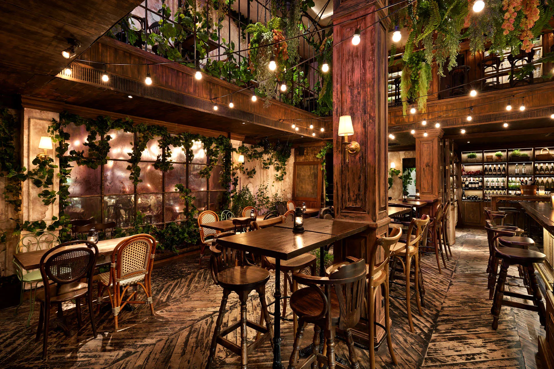 Double-height atrium with ivy walls, mirrored panels and rattan chairs — The Bar Upstairs Bangkok interior photography