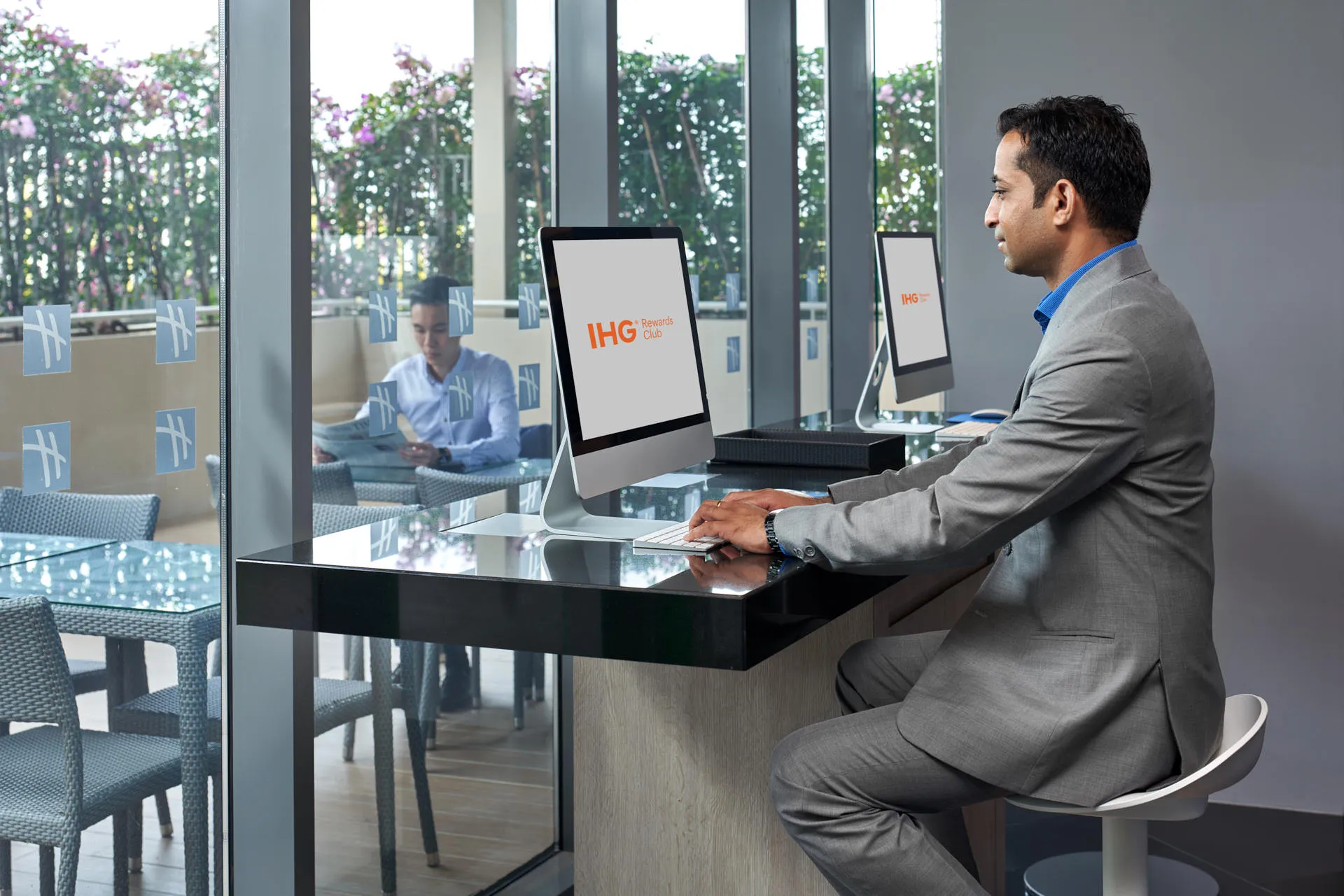 Guest using iMac in hotel business centre with terrace view — Holiday Inn Express Katong hotel photography