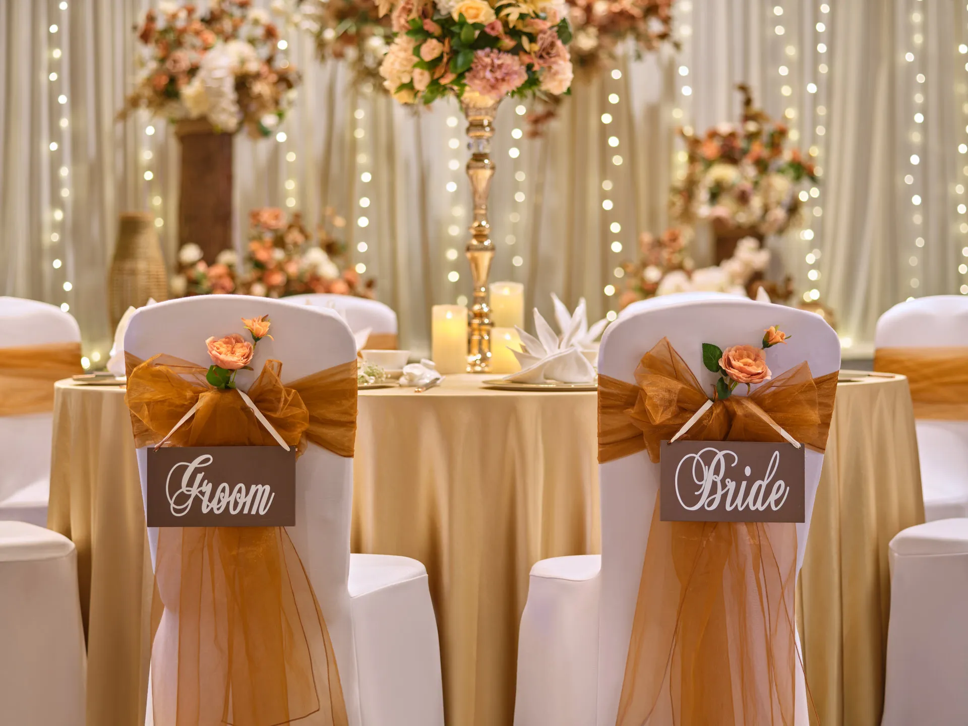 Sweetheart chairs with amber sashes and wooden name signs — voco Orchard Singapore wedding venue photography