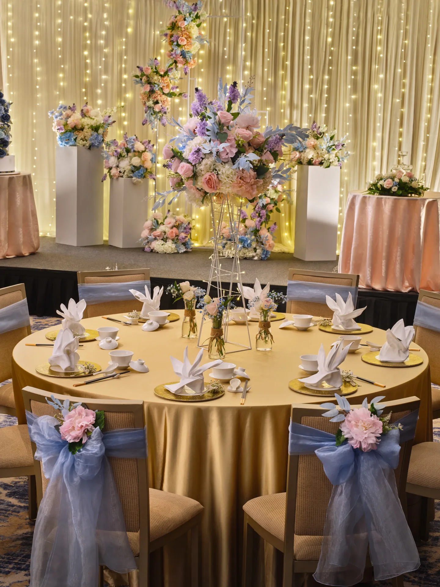 Chinese banquet table with gold chargers, pastel floral centrepiece and fairy lights — voco Orchard Singapore wedding photography