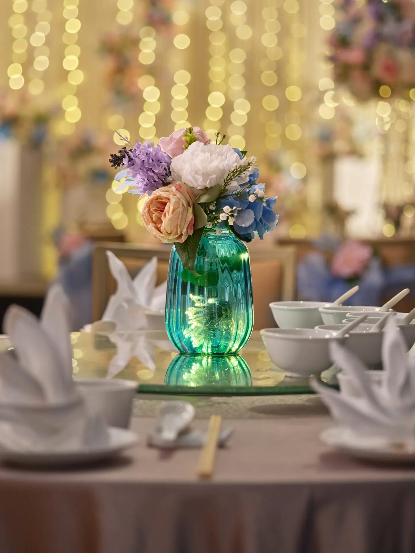 Teal glass vase centrepiece with fairy lights and pastel floral posy — voco Orchard Singapore wedding photography
