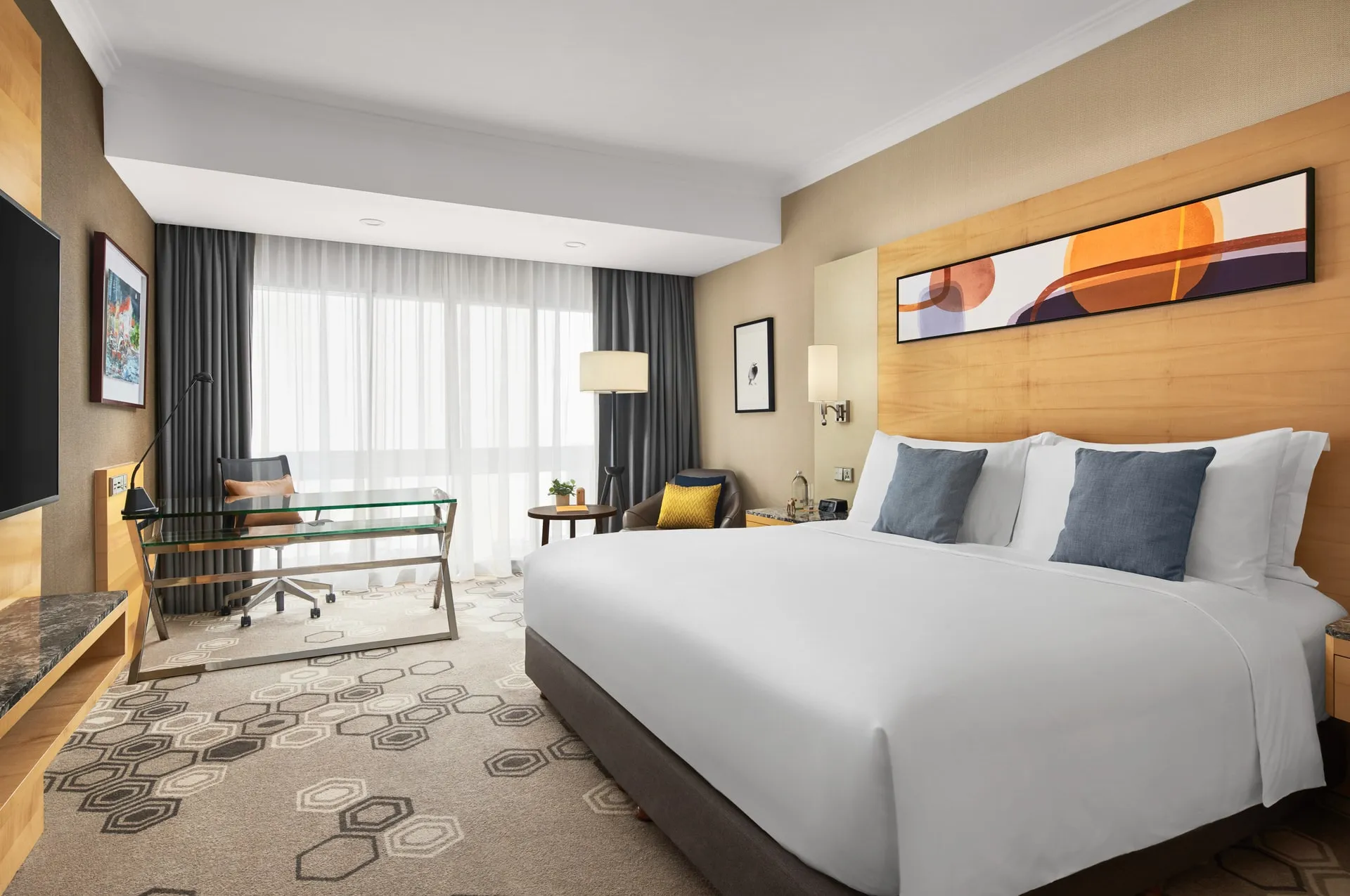 Wide room view with blue pillows, desk nook and seating area — voco Orchard Singapore hotel photography