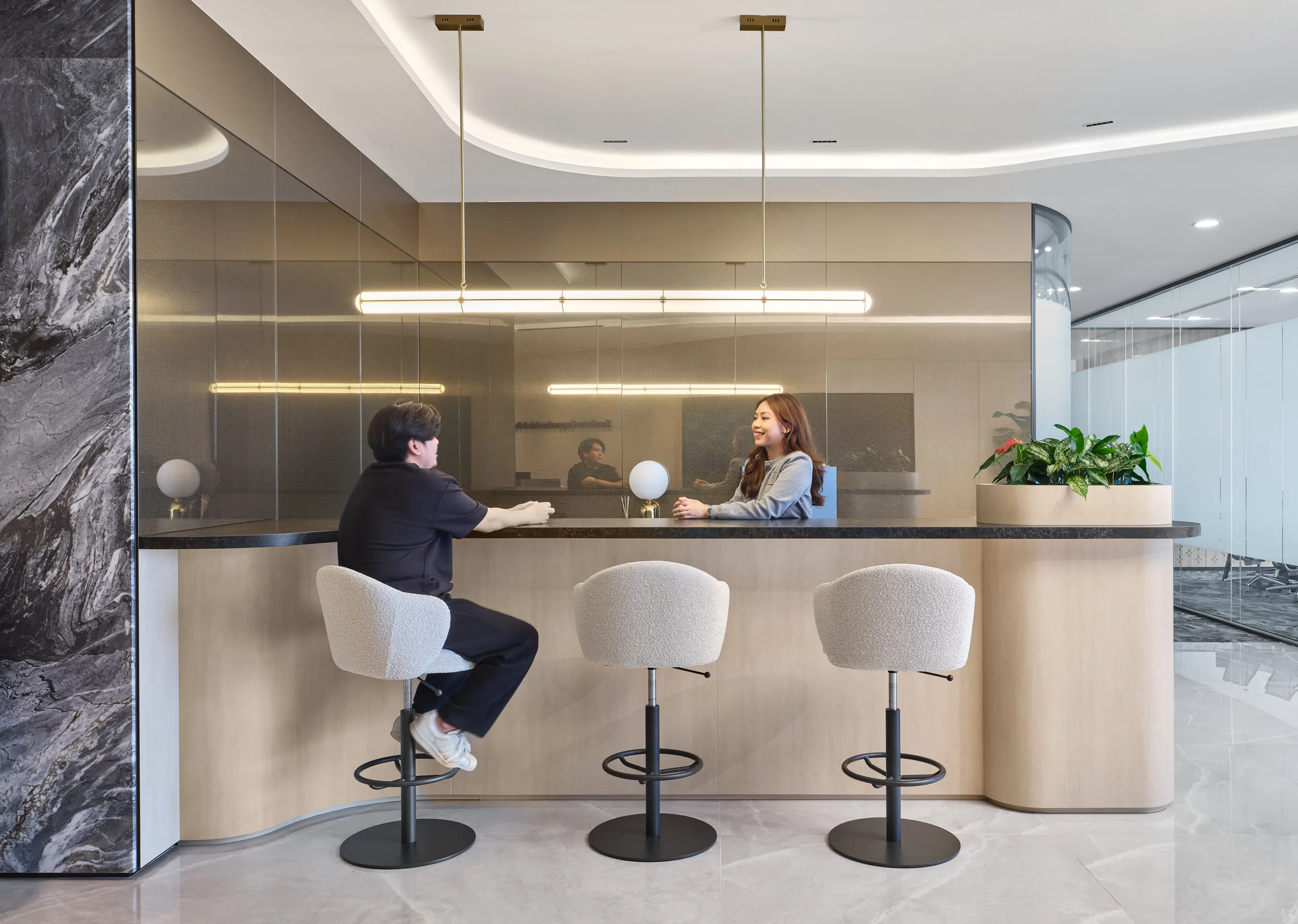 High-top bar counter with bouclé stools, globe lamps and brass pendants — Singapore workplace photography