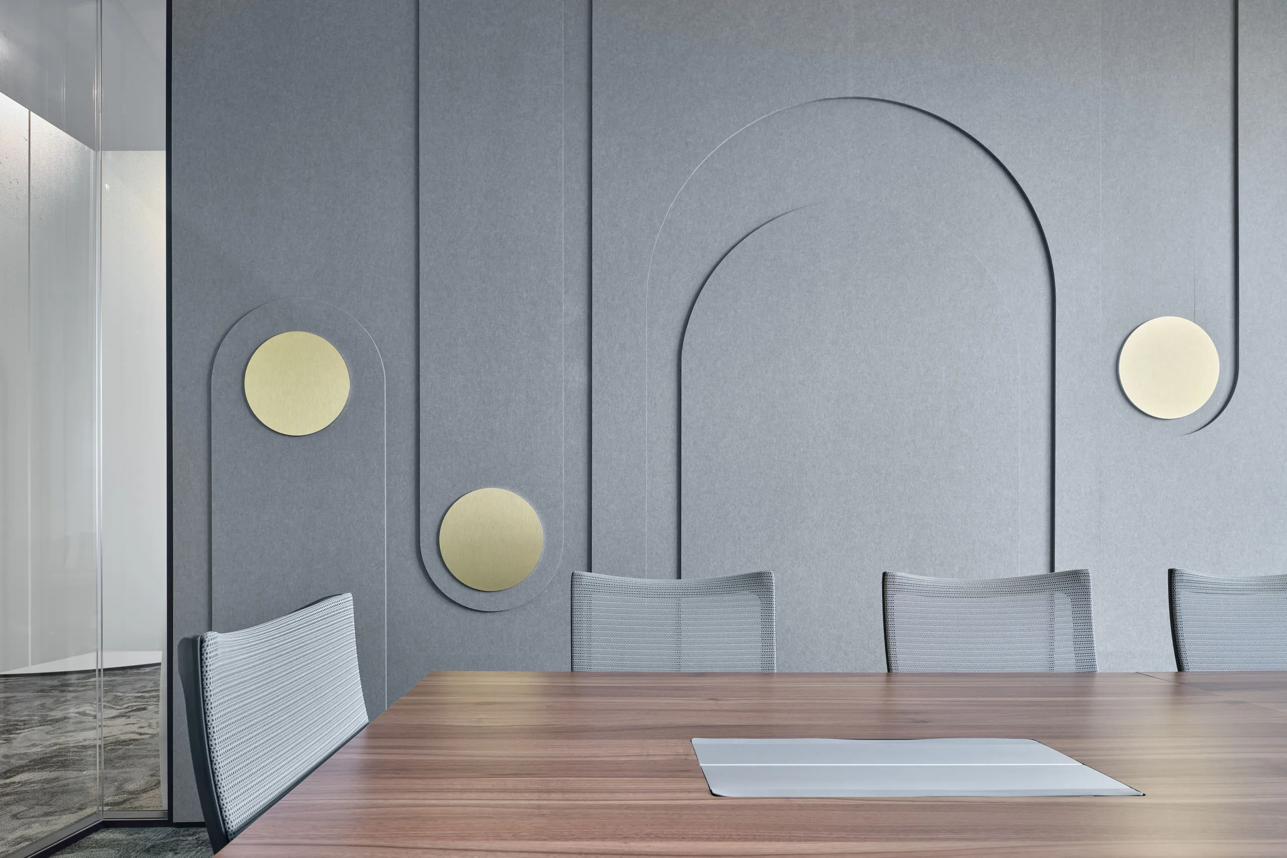 Meeting room with sculpted felt acoustic wall and brass disc sconces — Singapore office interior photography